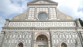 黒と白の大理石のファサードが美しい教会。教会の前は…