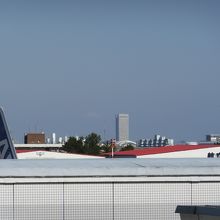 JRホームから。駐機中の垂直尾翼と航空大学校の格納庫が。