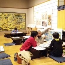 寺子屋ではボランティアの方が、見学者に教えている。