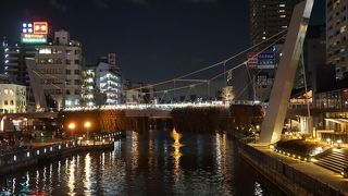 暗い中にライトアップされた吊り橋が浮かんで