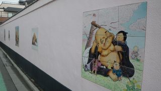 ピンクの壁にポップな布袋様のイラスト