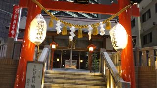 後ろを電車が走り，前は７車がひっきりなしに行き交う交差点にある神社