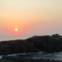 ウミネコ繁殖地の経島（ふなしま）の向こうに落ちゆく夕日。