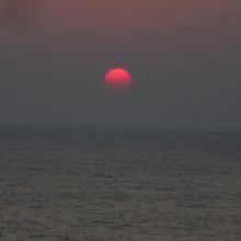 日御碕灯台下から見る、徒然なく没しようとする真っ赤な夕日。