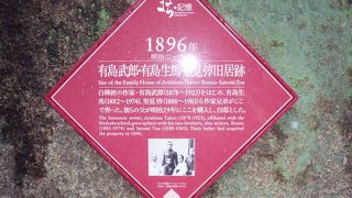 写真付きの赤ピンク案内プレートが高級マンションの石垣にあります。