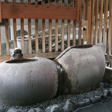 ひょうたん型のつくばいに温泉が注がれています