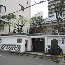 なまこ壁と黒塗りの門が際立つ屋敷の外観