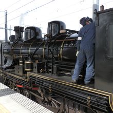 蒸気機関車の乗務員が点検中です。