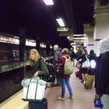 ホームで列車を待つ人たち、でも席の確保で皆血眼状態