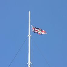 ユニオンジャックに王室紋章が入った外交旗が見えます。