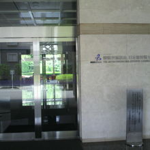 日本語国際センターの正面玄関の入口ガラス戸と壁の標識です。