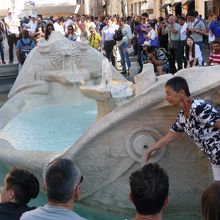 子舟の形の噴水、男性が水をペットボトルに注入中