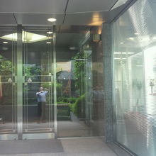 大使館の玄関右側に、ブラインド越しに展示室が見えます。