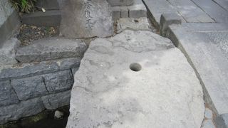 左側に丸い穴の開いた石があります