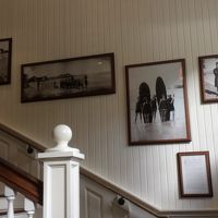 ２階への階段の壁を飾る昔の写真。