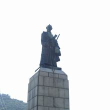 右手に論書、左手に衣装を持っている。