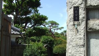 狩野芳崖のお墓と板碑があり、寺の隣りは七福神そばが名物の蕎麦屋