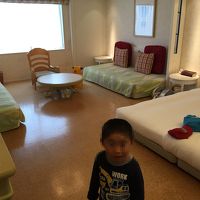 4人がゆったり寝れるベッドと窓際にはソファー。中央には丸テー