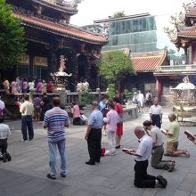 龍山寺でお祈りを唱える地元の人々