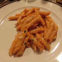 ディナー料理は、ペンネ、サラダ、スライス豚肉