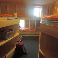山小屋の寝室は１〜２段の板の間に敷き布団と毛布が備えてある。