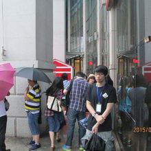 台風の影響で雨、風強い中、多くの人が集まる。