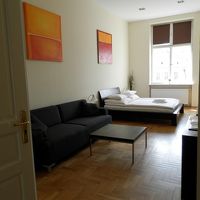 広い寝室、大きなソファ、フロアライト、ライティングデスクあり