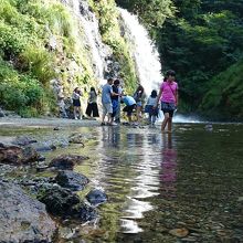 滝の周辺で水遊びを楽しむ