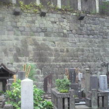 隣接する須賀神社との間の石垣と墓石の状況です。