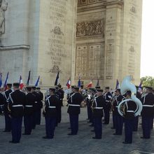 凱旋門下に入場するフランス国旗の行列とブラスバンド