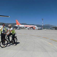 空港職員は自転車で滑走路を移動しています。