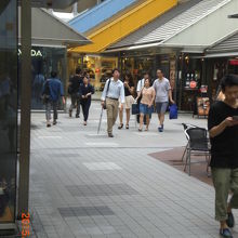 モザイク通り両側の店舗の様子と通りを歩く人々の様子です。