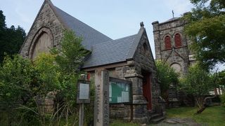 鹿沼石を張ったという白い壁面に優しい色調のステンドグラス