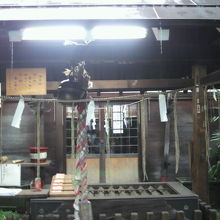 手前にさい銭箱、奥に板張りの本殿があります。