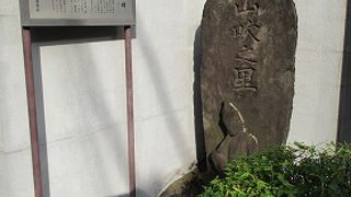 オリジン電気の正門脇に建つ石碑