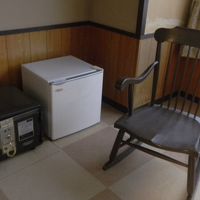 ベッドの前に金庫と冷蔵庫とロッキングチェアがありました。