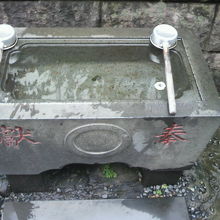 有楽稲荷神社の本社の左にある水鉢です。水が張られています。