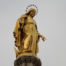 塔の上の金色に輝く聖母マリア像