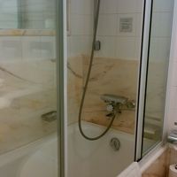 見た目は良いが手すりもなく、ガラス扉の敷居が邪魔な浴槽