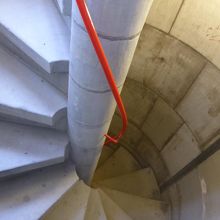 狭くて急な螺旋階段。手すり付き。