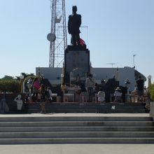 大将の銅像の前に額ずき祈りを捧げる多数のタイ市民の様子です。