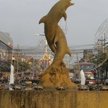 イルミネーションの配線を背にするイルカの像です。