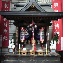 朝日稲荷神社の地上部の社の奥舎です。赤色の幟が立っています。