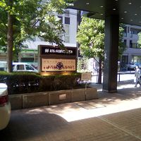 ホテル前にファミマ　都会なのに木々の木漏れ日よろし