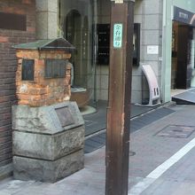 レンガ遺構の碑です。街路灯に青色の金春通りの標示が見えます。