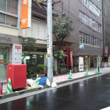 木挽町通りの宝珠稲荷神社の赤い鳥居が見えます。郵便局の傍です