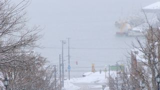 坂の向こうに路面電車、海が続く景色良い場所。
