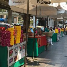 お祈りに使う花輪やろうそくが売られる店がズラリ