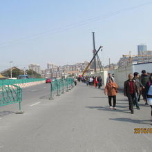 龍華寺を目指して工事の塀沿いに歩いて行く人々。