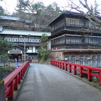 赤い橋を渡った先に建つ積善館